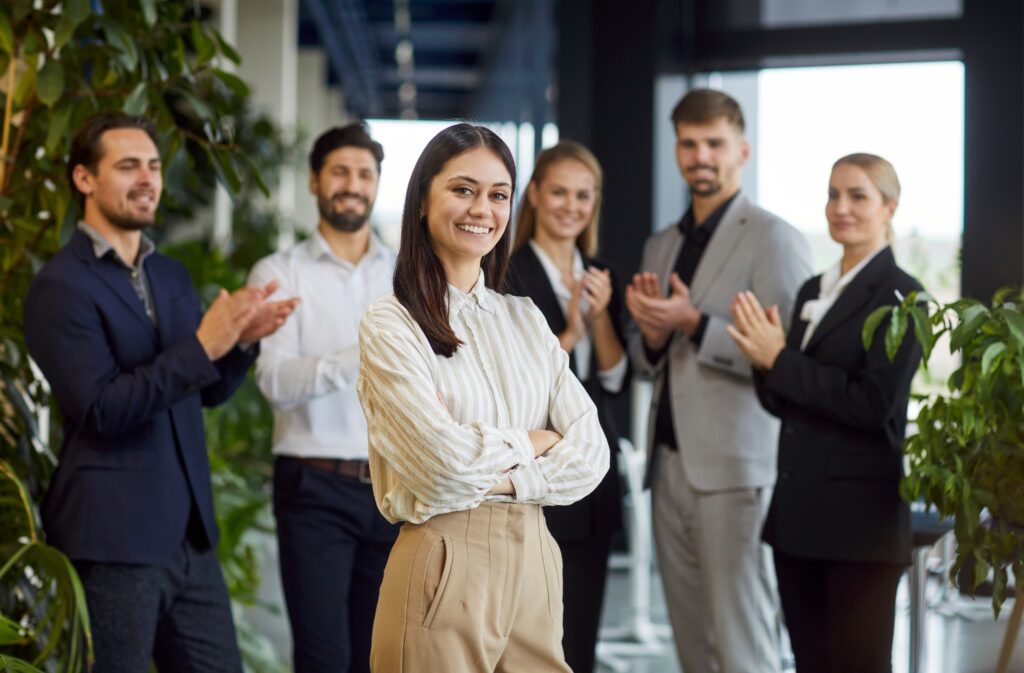A young business professional being celebrated by her peers.