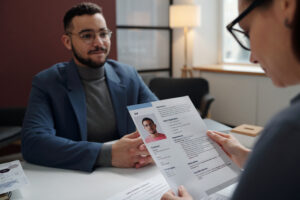A job applicant presenting his resume to a hiring manager in person.